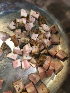 pork belly in a pan ready to cook before adding cabbage
