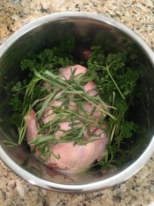 whole chicken in an instant pot with fresh parsley and thyme
