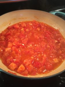 tomatoes in pan after simmering to break them down