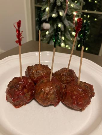 Cranberry Meatballs coated in sauce and skewerd on toothpicks.